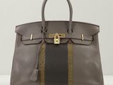 un sac à main marron et noir posé sur une table blanche