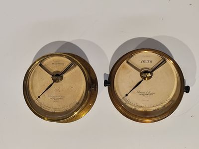 une paire de cadrans d'horloge anciens en laiton sur un fond blanc