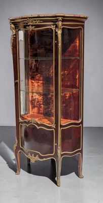 an antique display cabinet with a glass door and gold trimmings