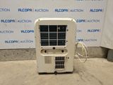 a small air conditioner sitting on the concrete floor