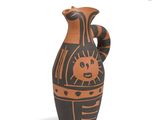 a black and orange vase with a sun design on it