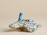 une petite figurine représentant un phare perché au sommet d'un rocher