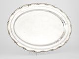 une assiette en argent avec un motif décoratif sur le bord
