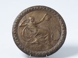 une image représentant une plaque en bronze sur laquelle figure une femme à cheval