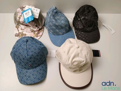 several hats are lined up on a table with tags on them