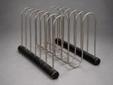 four metal tubes are stacked on top of each other on a gray surface