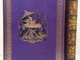 the book is purple with gold trimmings and a picture of a man sitting at a table