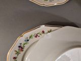 two plates with flowers on them on a table