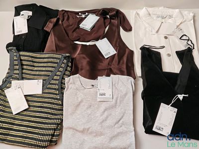 beaucoup de vêtements posés sur une table, avec leurs étiquettes