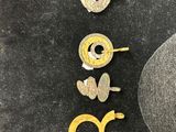two pairs of earrings are sitting on a table next to a pair of scissors