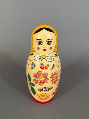 a small wooden matry doll with flowers on it