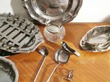 a wooden table topped with assorted silverware and utensils
