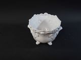 a small white bowl sitting on a black table