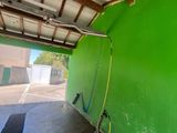 un mur végétal dans un garage, auquel est raccordé un tuyau d'arrosage