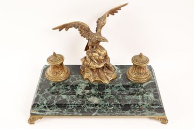 a statue of an eagle sitting on a marble base