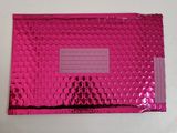 a pink metallic foil envelope with a window on top of it
