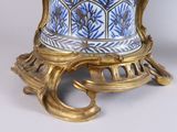 a blue and white vase sitting on a gold stand