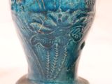 a blue vase that is sitting on a white surface