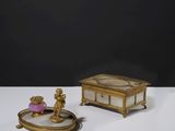 une petite boîte en or surmontée d'une figurine