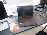 un ordinateur portable posé sur un bureau, à côté d'un écran d'ordinateur