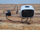 a small white and black speaker sitting on a wooden table