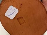 a person holding a piece of wood with a sticker on it