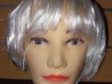 une tête de mannequin coiffée d'une perruque argentée