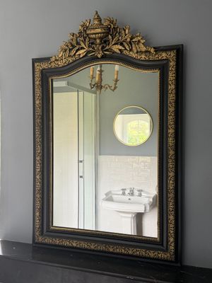 un miroir sur le mur au-dessus d'un lavabo dans une salle de bains