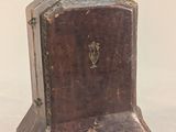 a small wooden box with a gold decoration on top of it