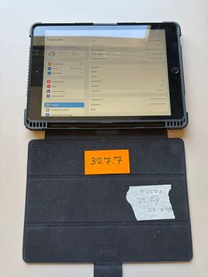 a tablet computer sitting on a table with a sticky note attached to it