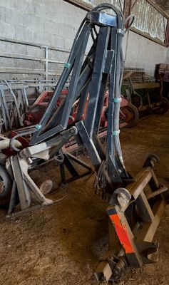un homme debout à côté d'une machine dans une grange