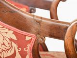 a close up of a wooden chair with a red and white pattern on it