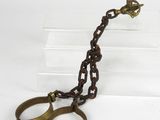 une paire de menottes auxquelles est attachée une chaîne