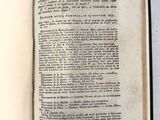un livre ouvert posé sur une table, sur lequel est collé un autocollant