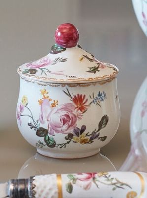 a pen sitting on a table next to a bowl and vase