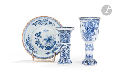 deux vases bleus et blancs et une assiette posés sur un présentoir