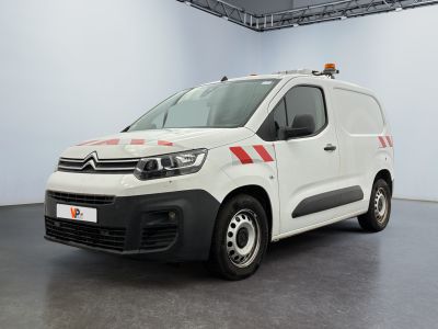 La camionnette blanche est garée dans une pièce blanche ; elle porte une bande rouge sur le côté.