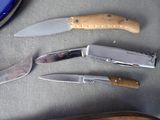 three knives and a knife sharper on a table