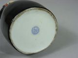 a close up of a black and white vase with a blue circle
