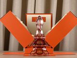 an orange glass sculpture on a table with a box