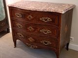 a marble top chest of drawers in the corner of a room