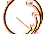 a gold brooch with pearls in it on a white background