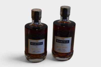 two bottles of whiskey sitting next to each other on a white surface