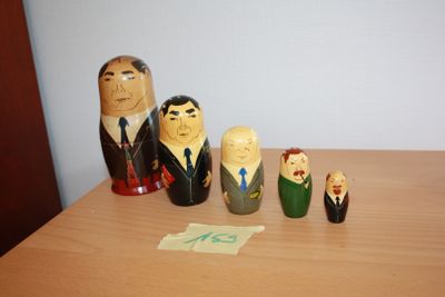 five wooden figurines of people on a wooden table