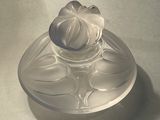 a glass bowl with a flower on it on a table