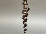 an old metal candle holder with a spiral design on top of it