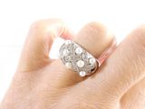 a woman ' s hand holding a ring with pearls on it