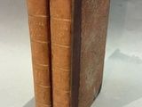 two old books that are sitting on a table
