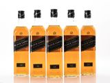 four bottles of johnnie black label whisky lined up on a white surface