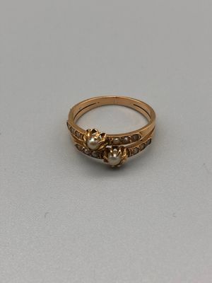 Gros plan sur une bague en or ornée d'une perle